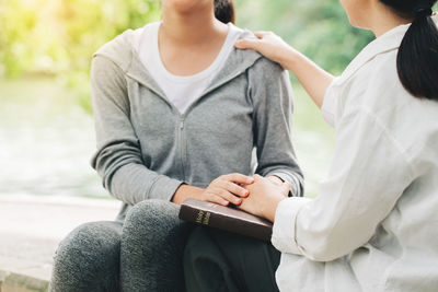 Midsection of couple sitting outdoors