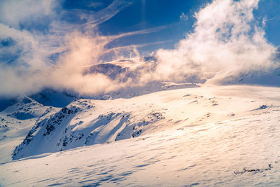 Scenic view of snow covered mountains against sky