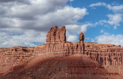 Ruins of rock formations against cloudy sky