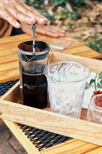 Close-up of hand holding drink on table