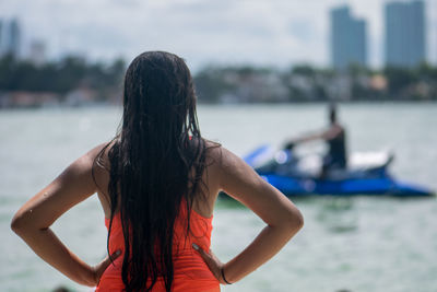 Rear view of woman against sea against sky