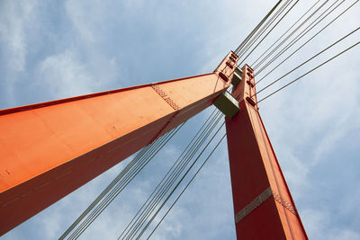 Low angle view of suspension bridge against sky