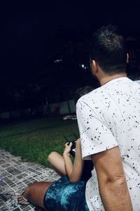 Rear view of man using mobile phone