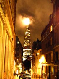 Low angle view of illuminated buildings against sky at night