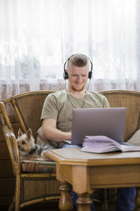 Young man using mobile phone while sitting on table