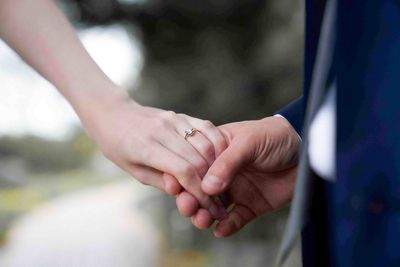 Cropped image of couple holding hands