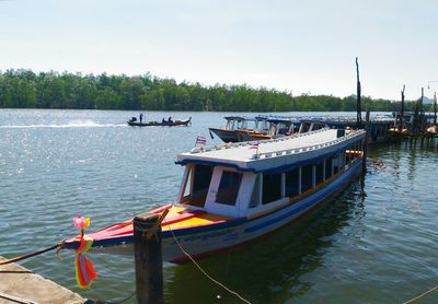 Boats moored in lake against sky