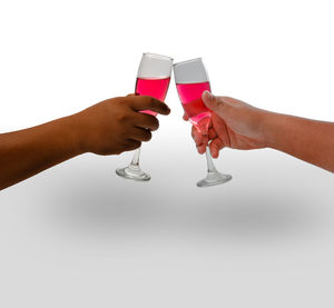 Midsection of man holding drink against white background