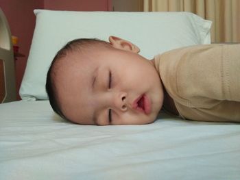 Close-up of a baby sleeping on bed