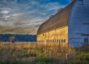 Built structure on field against cloudy sky