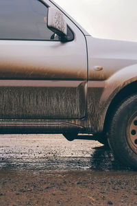 Close-up of dirty car on wet road