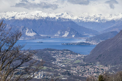 Aerial view of snowcapped mountains by sea against sky