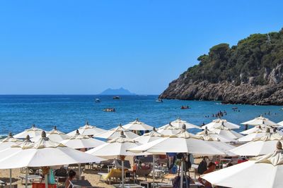 Scenic view of beach against clear blue sky