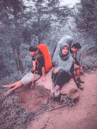 People sitting on street amidst trees in forest