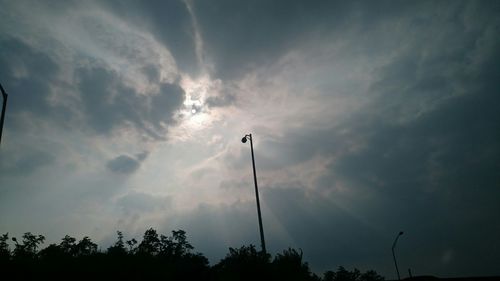 Low angle view of street light against cloudy sky