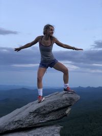 Full length of woman on rock against sky