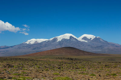 Scenic view of mountains against blue sky