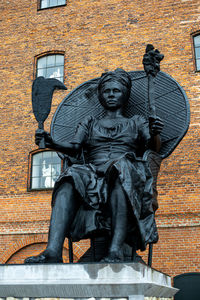 Statue against wall and building