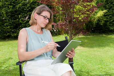 Young woman smiling while sitting in park