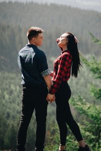 Young couple standing face to face in forest