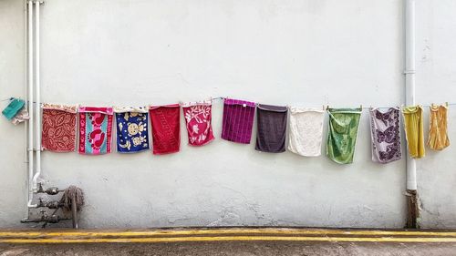 Towels drying on clothesline against wall
