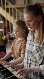 Mother and daughter playing piano