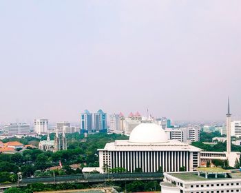 Buildings in city against clear sky