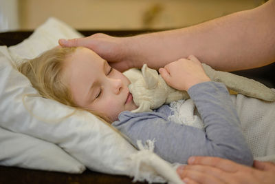 Dad strokes his sick child, looks with care, tenderness and love, holds the hand. the concept of