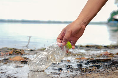 Close-up of hand holding fish at beach