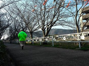 Rear view of woman walking on footpath