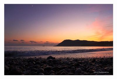 Scenic view of beach against sky during sunset