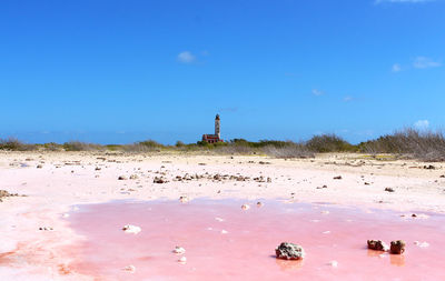 View of lighthouse on beach against sky