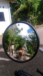 Reflection of man on side-view mirror