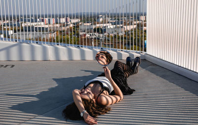 High angle view of woman with mirror lying outdoors