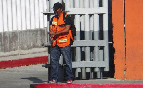 Man working against orange wall