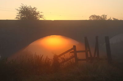 Sunbeam streaming through arch bridge during sunset