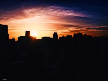 Silhouette cityscape against sky during sunset