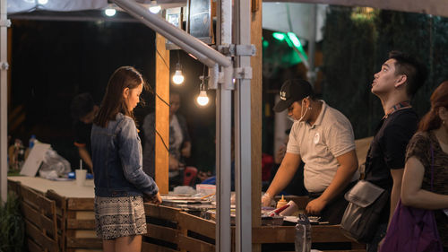 Women standing at illuminated store