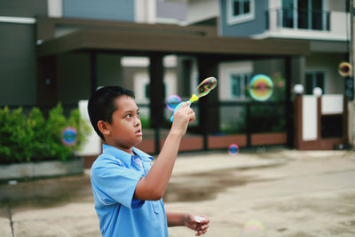 Side view of boy playing with arms raised