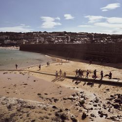 People at beach against sky