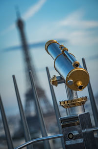 Close-up of coin-operated binoculars against sky