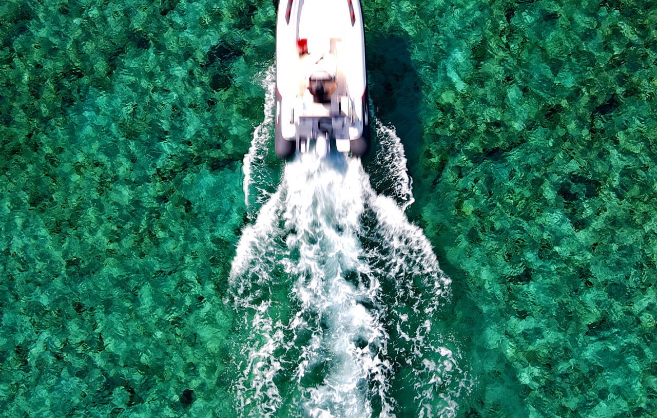 HIGH ANGLE VIEW OF MAN SWIMMING IN SEA