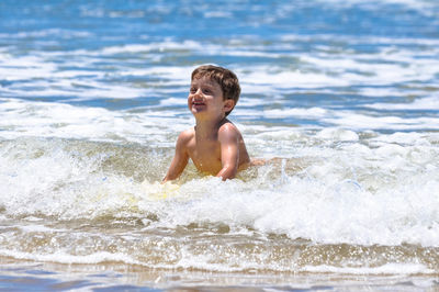 Full length of shirtless boy in sea