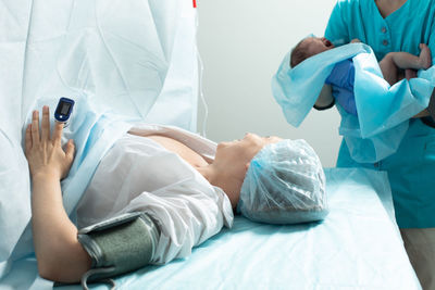 Midsection of doctor examining patient in hospital