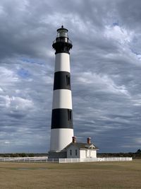 Low angle view of bodie island lighthouse against cloudy sky. cape hatteras national seashore