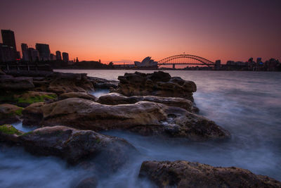 View of bridge and buildings against sky during sunset