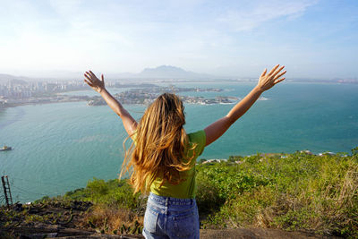 Girl on the mountain peak enjoys the wind on her face