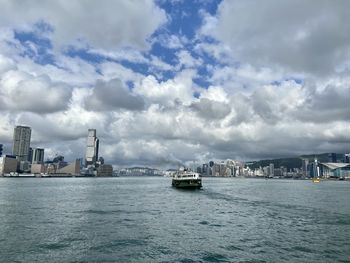 Boats in sea against cloudy sky