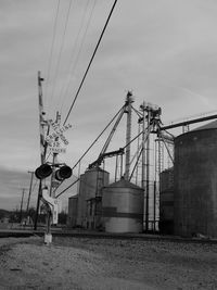 Low angle view of crossing sign against factory