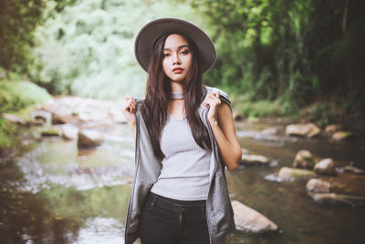 Portrait of young woman by river